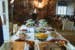 Buffet-ruokapöytä katettuna vanhan tiilirakennuksen tiloihin
