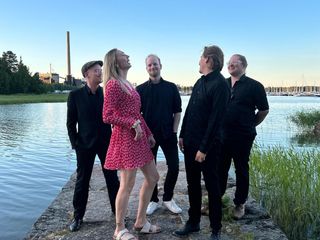 Bilebändin jäsenet laiturilla kesäillan valossa